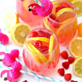 Pink Moscato Lemonade Recipe in wine glasses with lemons and raspberries