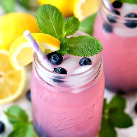 Blueberry vodka with pink lemonade served with frozen blueberries.