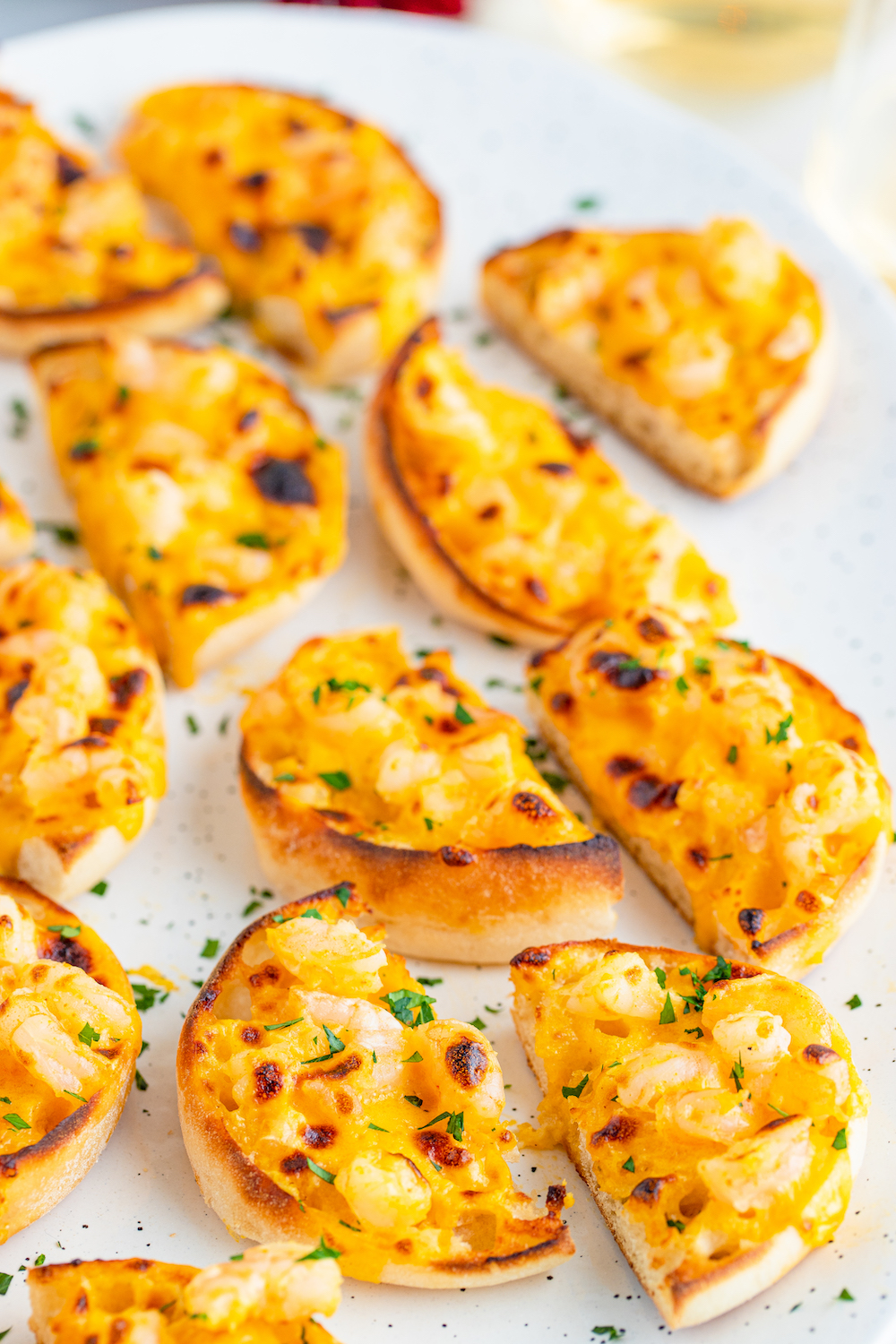 Shrimp Meltaways broiled to perfect on a white plate garnished with parsley.