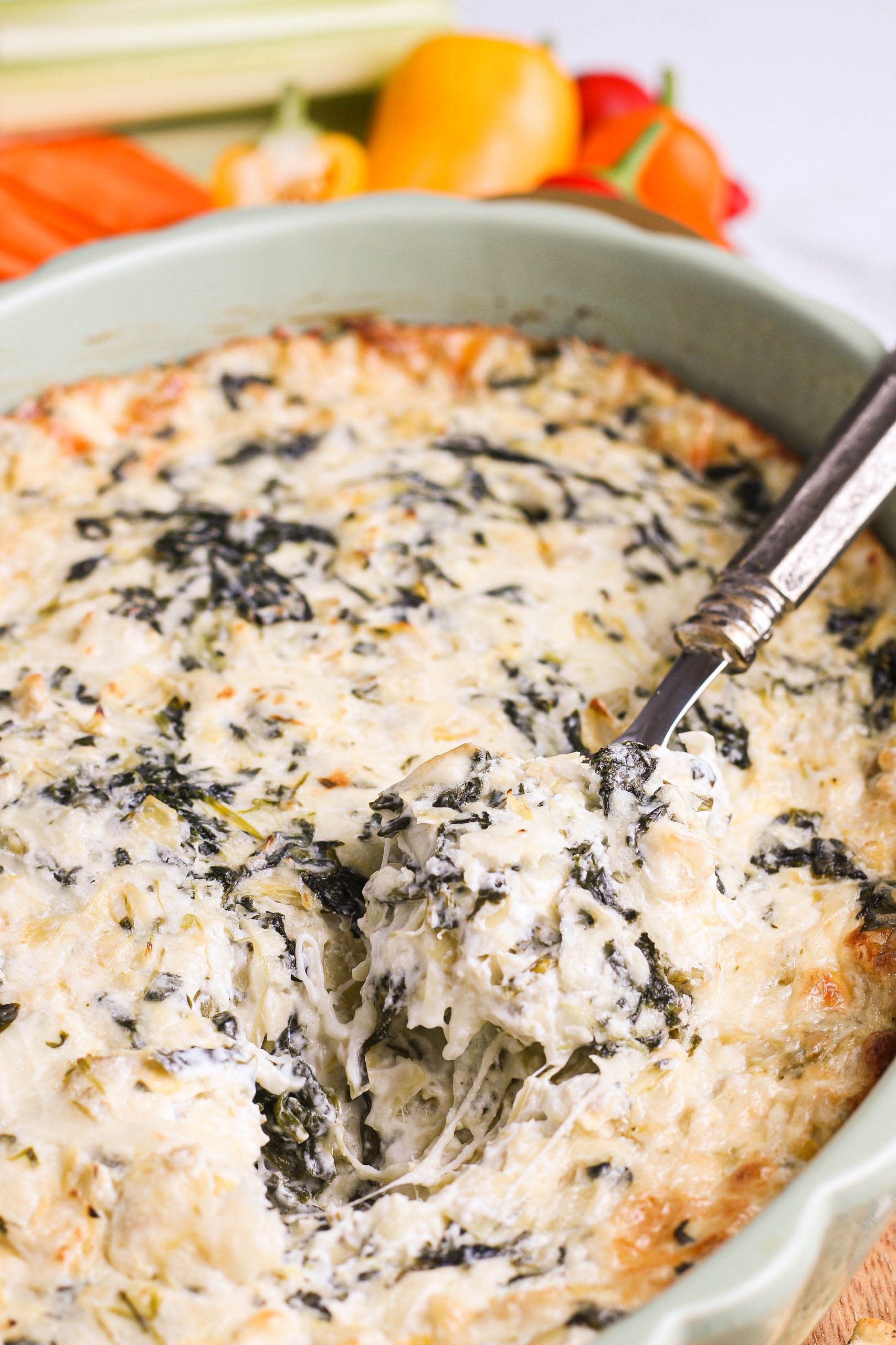 Spinach artichoke dip with spoon.