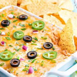 Easy Cheesy Bean Dip in white baking dish with tortilla chips