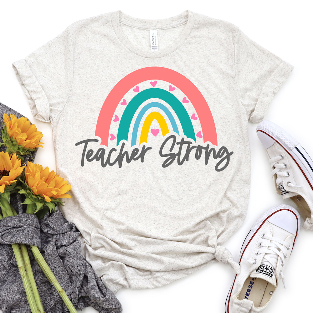 Rainbow Teacher Strong SVG on light gray shirt with sunflowers and tennis shoes.