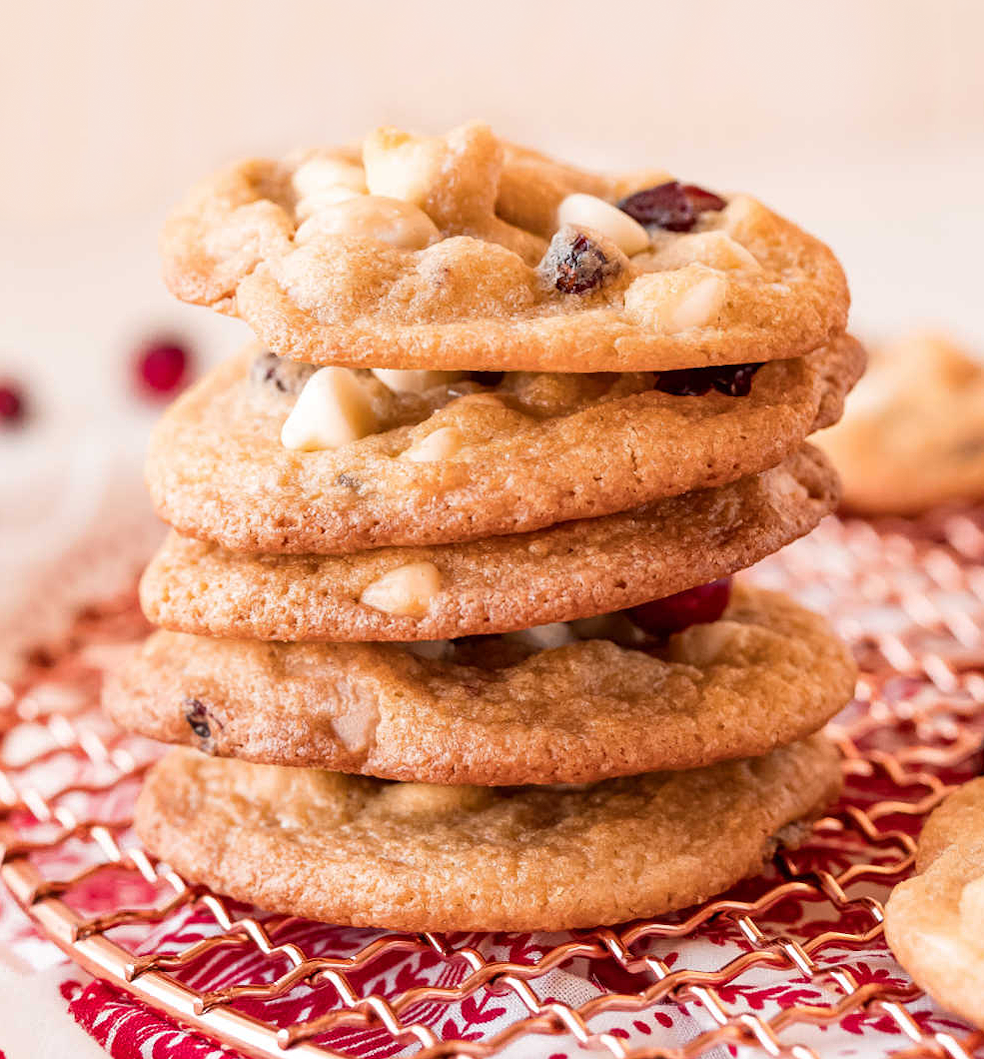 Cranberry White Chocolate Macadamia Nut Cookies stacked on cooling rack.