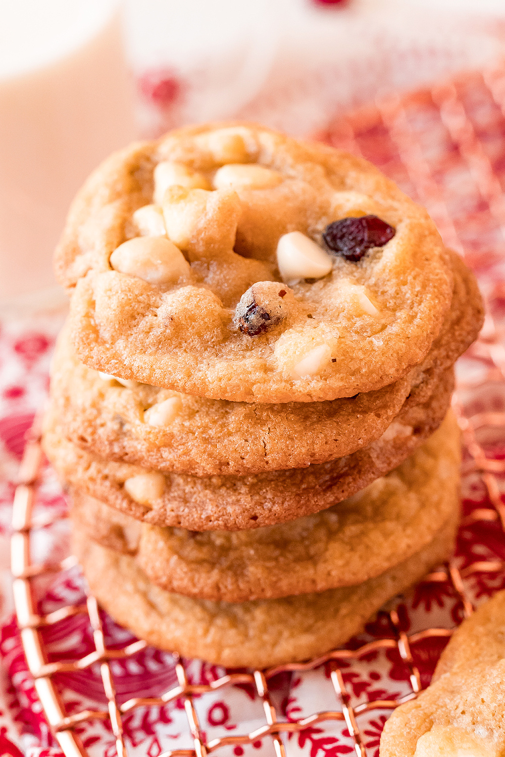 Cranberry White Chocolate Macadamia Nut Cookies stacked on red and white napkin.