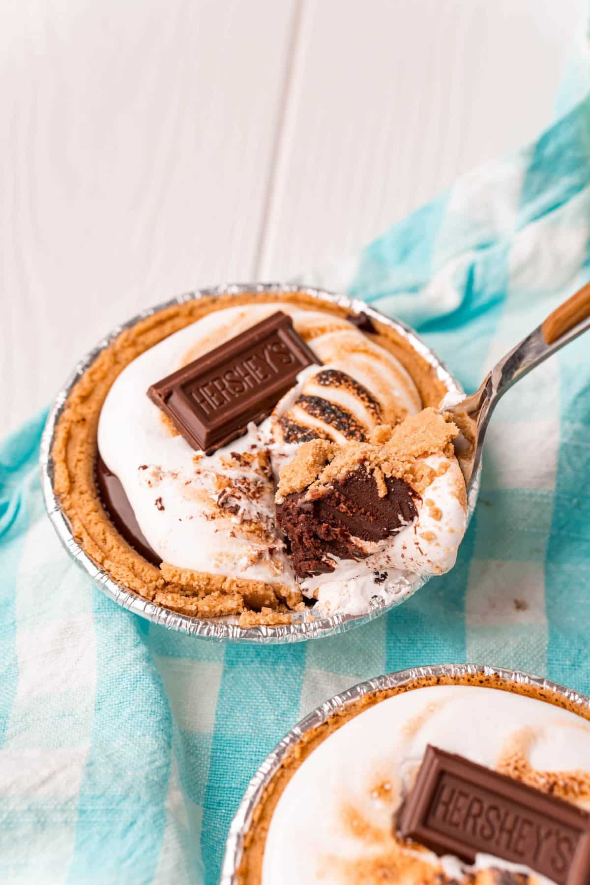 Mini S'more Pies with graham cracker pie crusts, chocolate, and marshmallows.