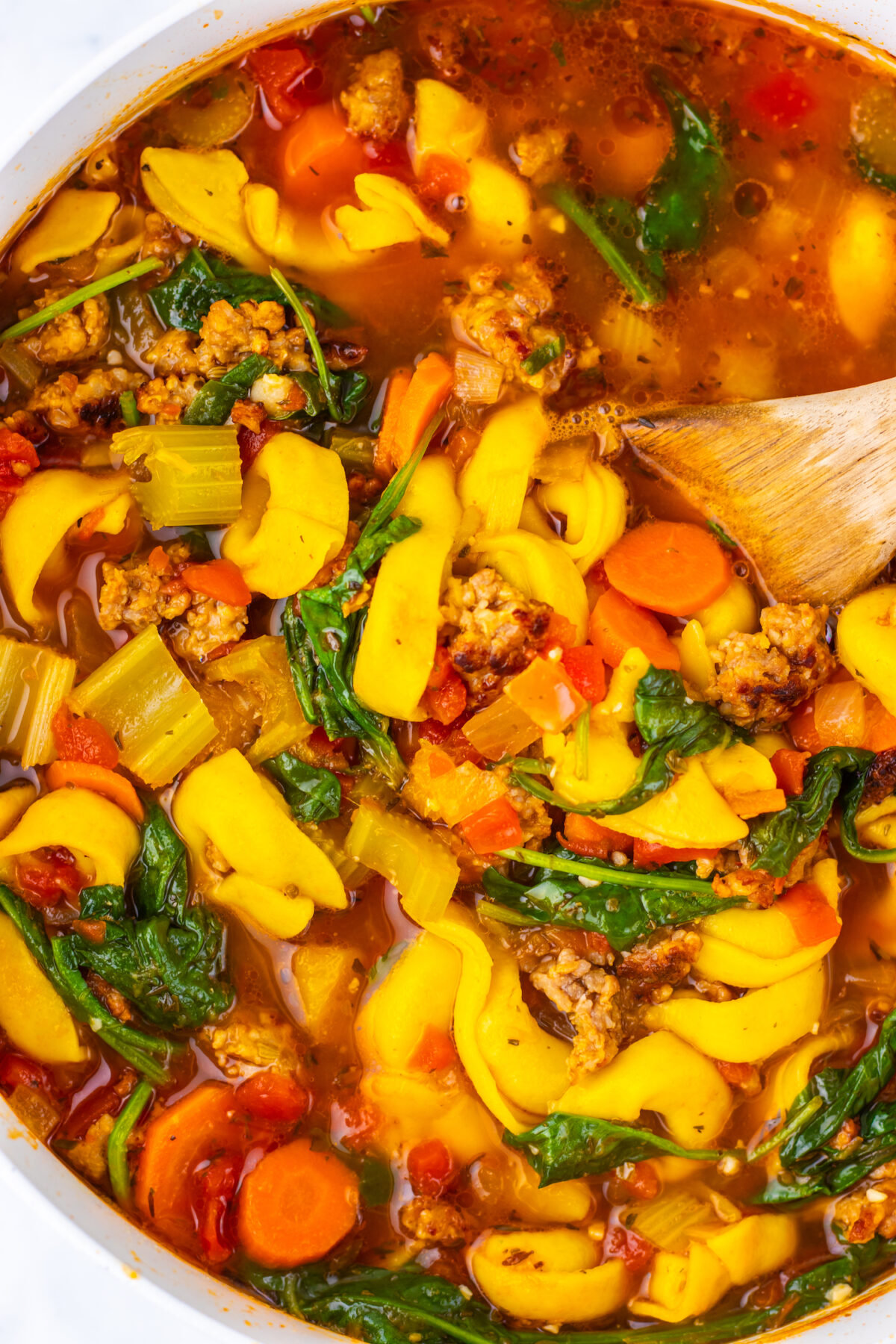 Close up of Sausage and Butternut Squash soup in large white pot.