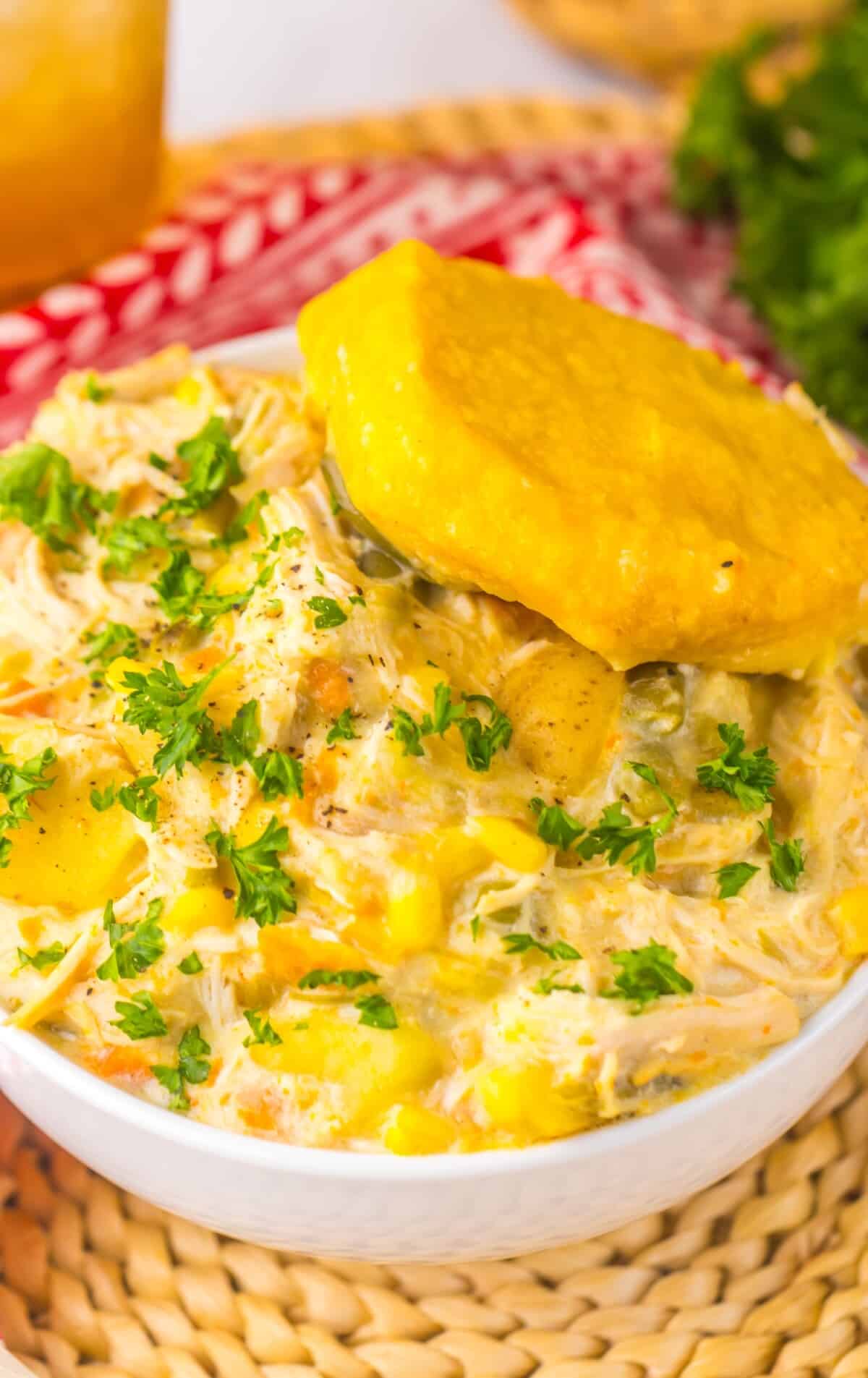 Homemade slow cooker chicken pot pie served in bowl with biscuit for dinner